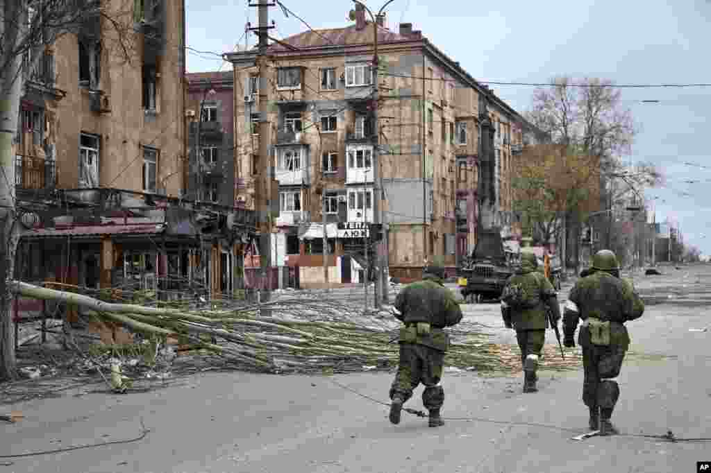 На фото &ndash; военнослужащие т.н. &laquo;ДНР&raquo; на разрушенных улицах Мариуполя. В середине апреля 2022 года битва за этот город, ставший одной из ключевых целей РФ на юге Украины, находилась в самом разгаре. В этот период российские силы установили контроль над центром города, полностью окружив завод &laquo;Азовсталь&raquo;. По данным ООН, в результате боев в Мариуполе были повреждены или уничтожены до 90% жилых зданий.