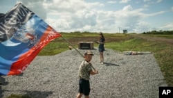 Архивное фото. Мальчик держит флаг самопровозглашенной и непризнанной ДНР на востоке Украины, 2015 год