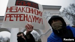 Мужчина держит плакат во время проукраинского митинга в Симферополе. 11 марта 2014 года.