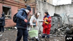 Раненые женщины покидают свой разрушенный дом в Харрькове, Украина. Февраль 2023 г