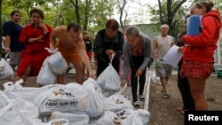 Украинские беженцы из Донецкой области получают продуктовую гуманитарную помощь в пригороде Мариуполя. 10 сентября 2014 г.